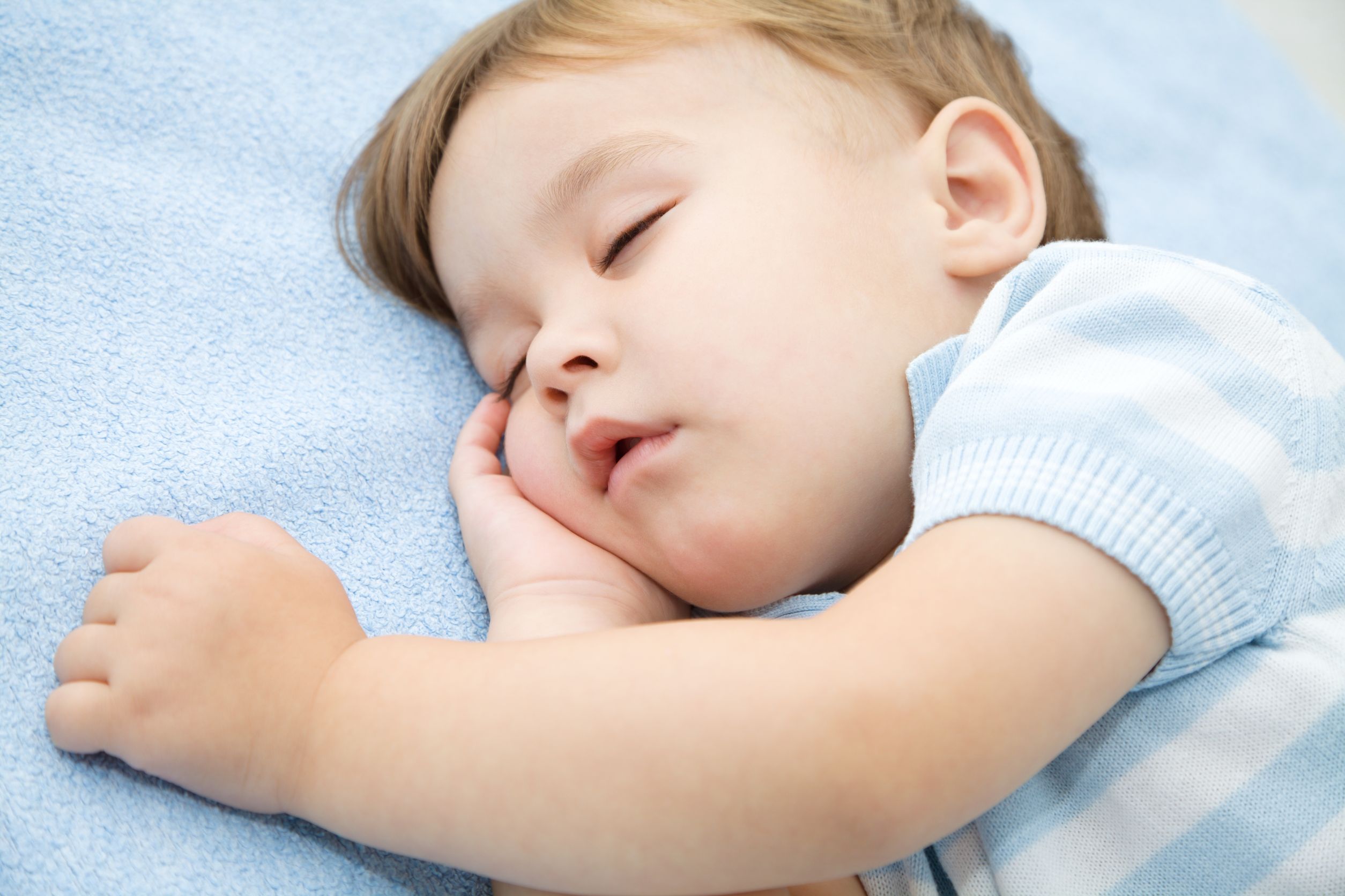 16521780-portrait-of-a-cute-little-boy-sleeping-on-white-pillow